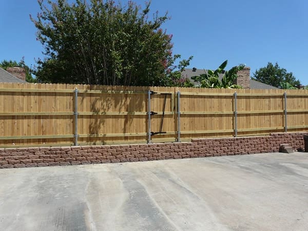 Cedar fence built on top of flagstone wall