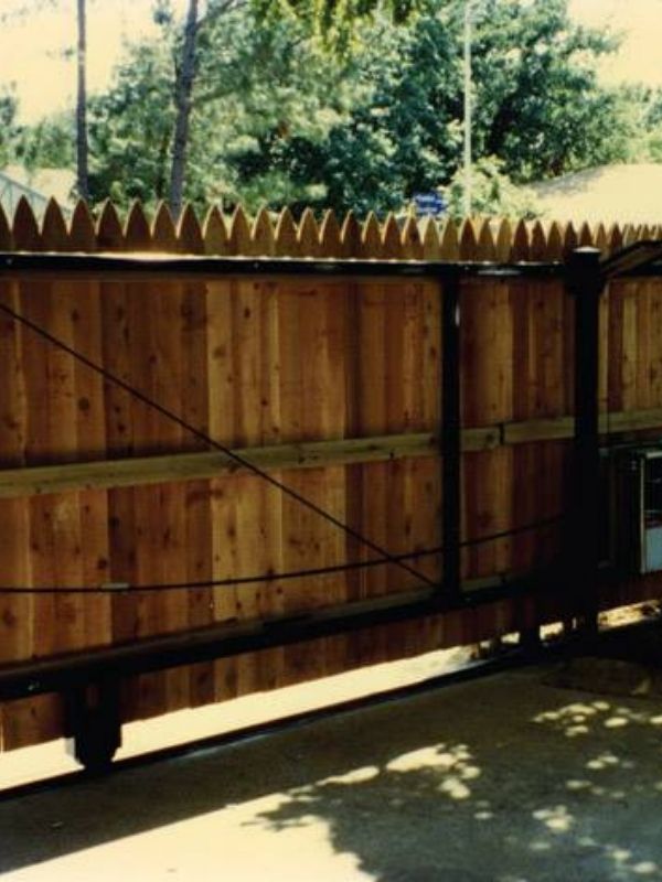 A wooden slide gate is installed on a residential property.