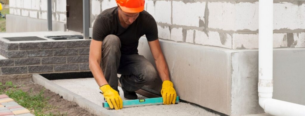 A man working on installing a concrete slab. 