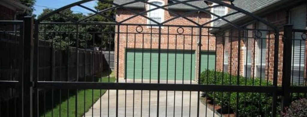 Concrete driveway installed on a residential property with a new gate. 