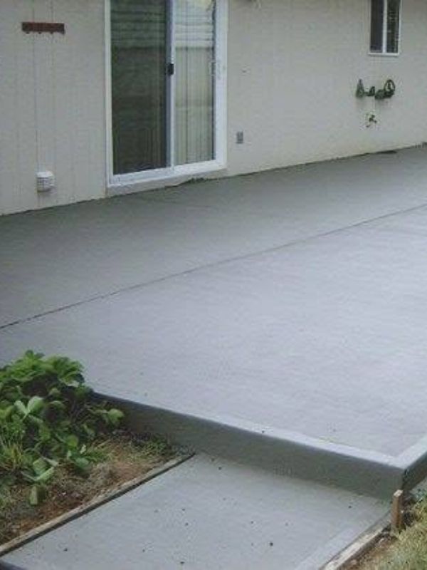 A concrete patio poured on the back of a residential property. 