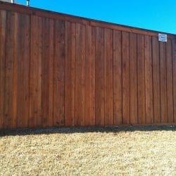 Stained board on board fence with kickboard, cap, and trim