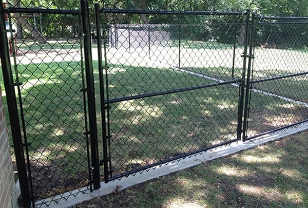 Chain-link fence on concrete curb with gate
